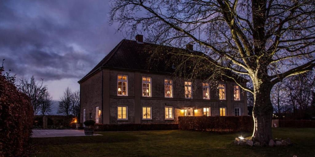 a large house with its lights on at night at Lindegaarden Kollund in Kruså