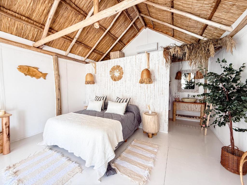 a bedroom with a bed and a wooden ceiling at Tribu Eco Beach in Francisco Álvarez
