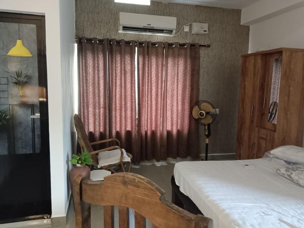 科钦G Hotels And Resorts的一间卧室，里面有一张床、一把椅子和一扇窗户