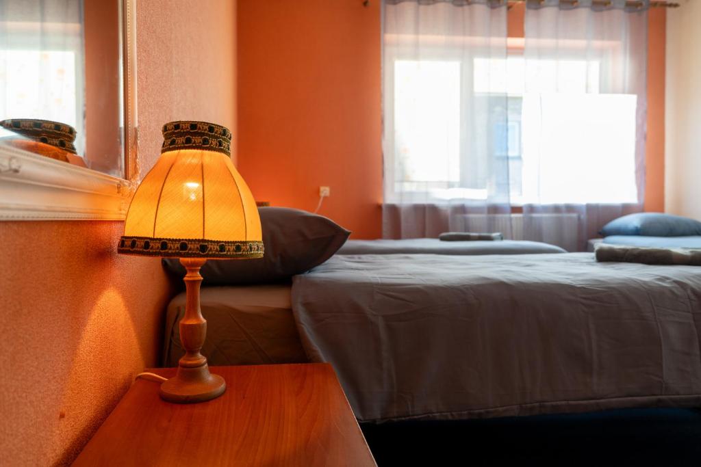 a lamp on a table in a room with two beds at Julias's House Self Check-in in Šiauliai