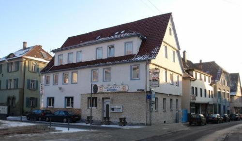 ein weißes Gebäude mit braunem Dach auf einer Straße in der Unterkunft Hotel Filoxenia in Stuttgart