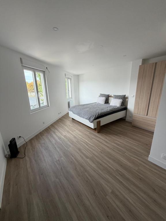 a white room with a bed and a window at Studio neuf à Crosne in Crosne