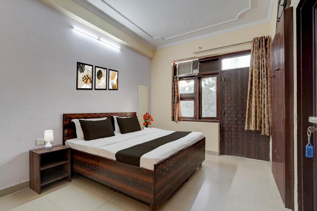 une chambre avec un grand lit et une fenêtre dans l'établissement Hotel O Jagatpura Central Railway Station Jaipur, à Jaipur