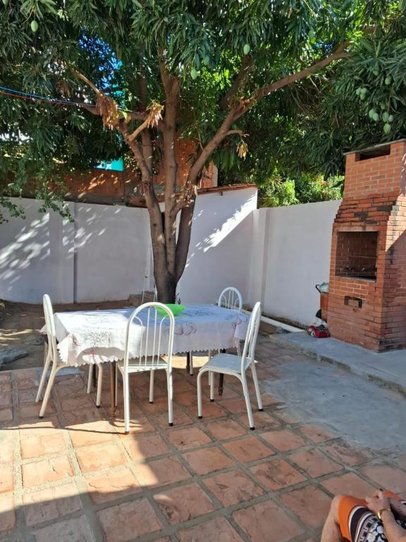 een tafel en stoelen en een boom in een tuin bij Casa de hóspede turistas e Romeiro in Bom Jesus da Lapa
