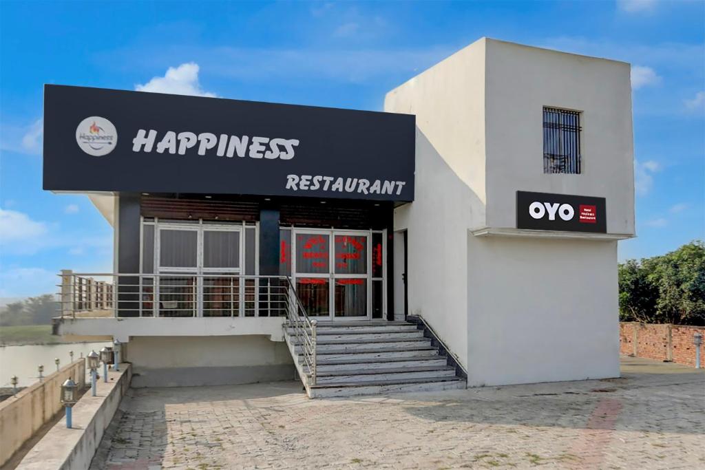 un bâtiment blanc avec une enseigne indiquant « restaurant happinessrxrx » dans l'établissement SPOT ON Happyness Restaurant, à Fatwa