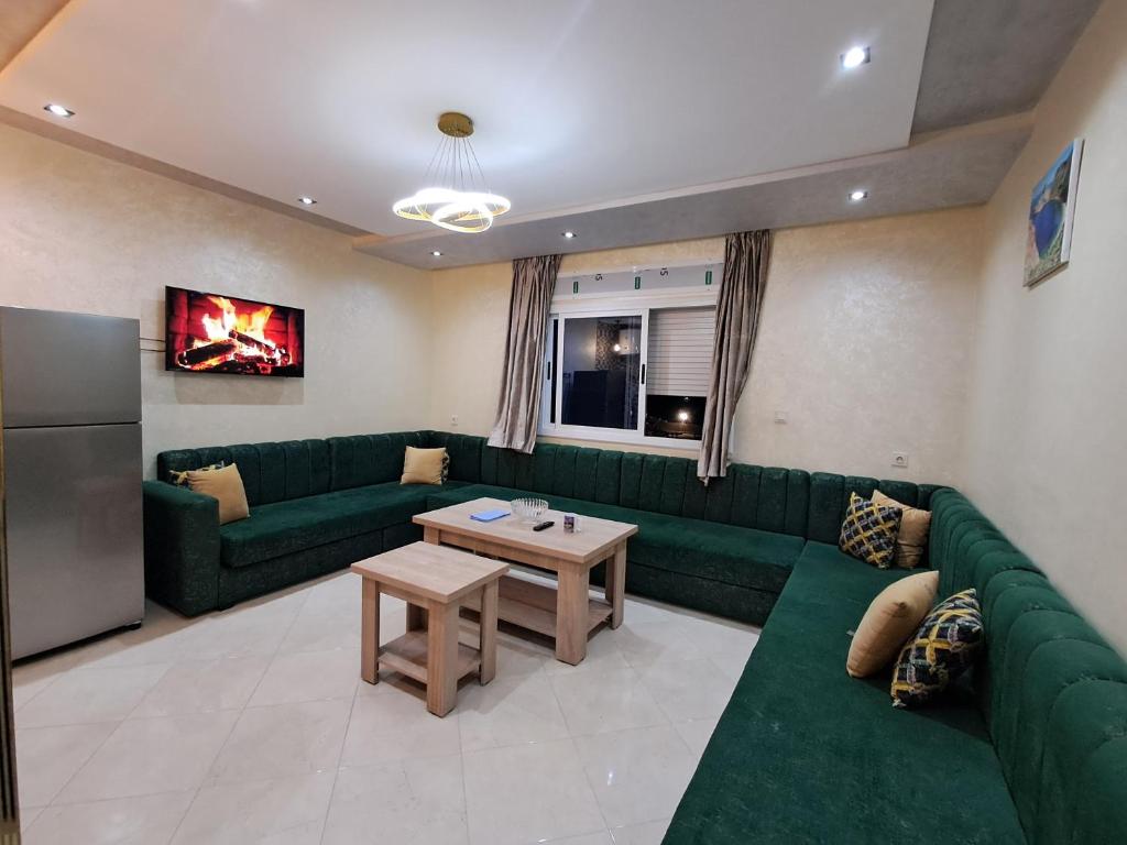 a living room with a green couch and a table at اقامة تورارن in El Jebha