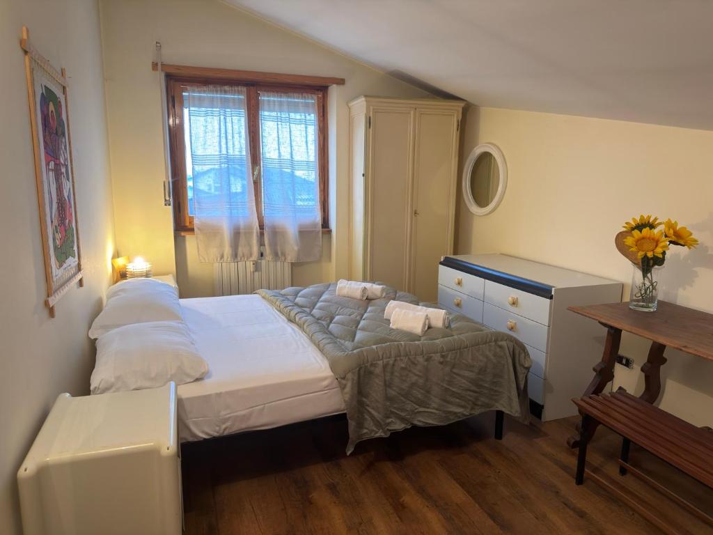una camera da letto con un letto, un comò e una finestra di Relax e Montagna con Vista a Bardonecchia