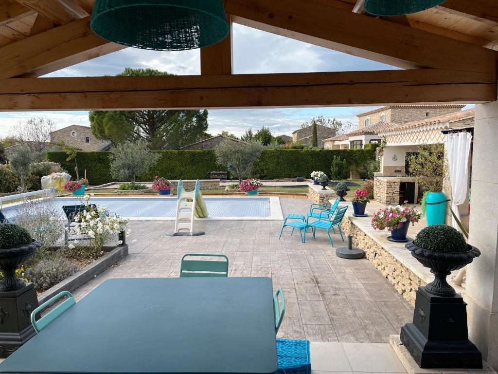 een terras met een tafel en stoelen en een zwembad bij Villa Rube in Coustellet