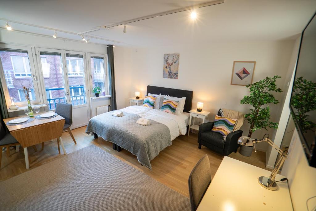 ein Schlafzimmer mit einem Bett und einem Tisch und Stühlen in der Unterkunft Rainbow Studio in Haga & Linné - Prime Location in Göteborg