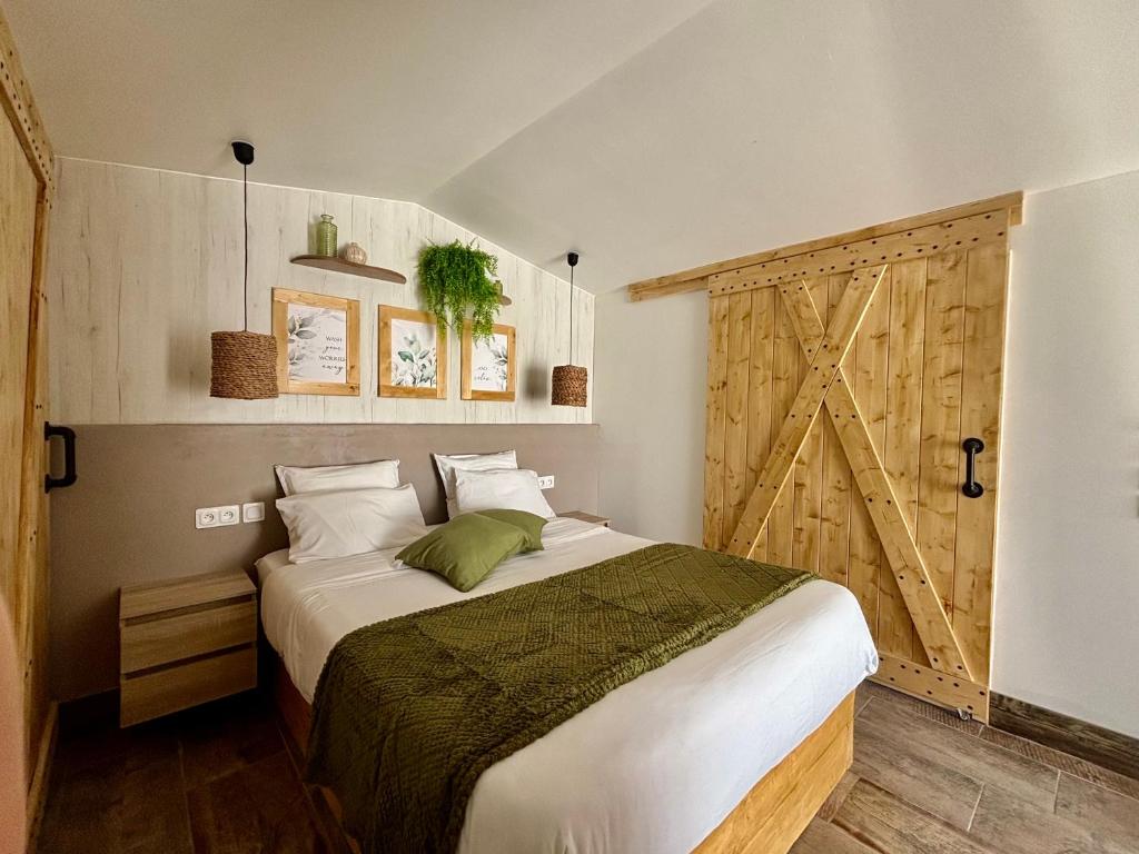 a bedroom with a bed and a barn door at La Salamandre de l Olivier - Le Magnolia in Aubignosc