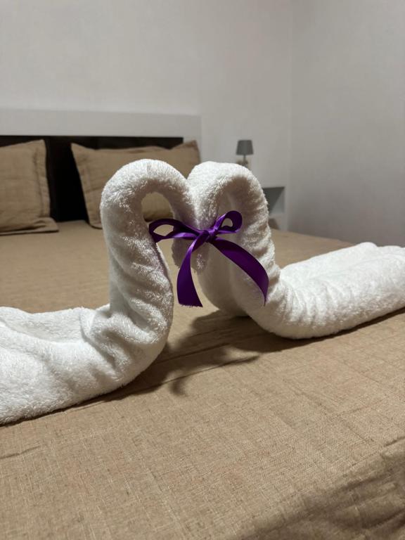 ein Handtuch in Form eines Schwans mit einer lila Schleife in der Unterkunft Peçi Apartments Gjirokastër in Gjirokastër