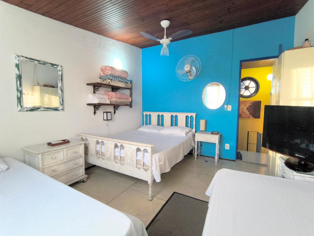 una camera da letto con due letti e una tv e pareti blu di Casa 12 Búzios Vilas a 500m da Rua das Pedras, top localização em condomínio lindo e calmo, portaria 24h a Búzios