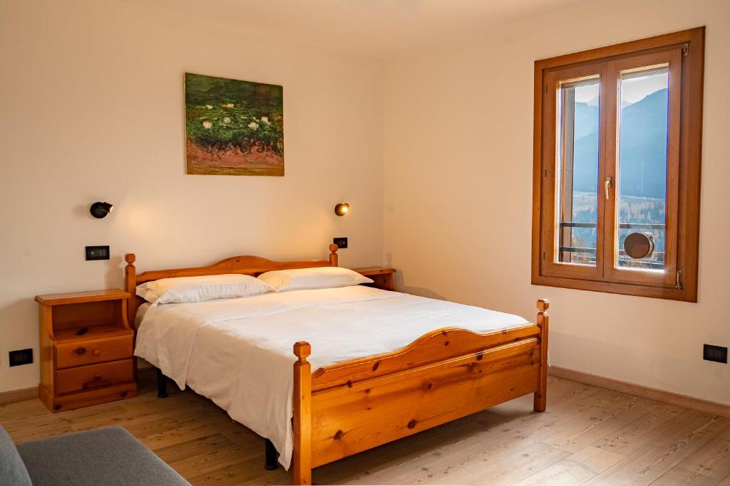 a bedroom with a wooden bed and a window at MH-Luxury Apartments in Cavalese