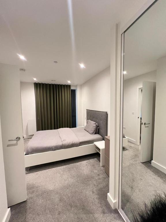 a bedroom with a bed and a large mirror at 2 Bedroom Brentford in Kew Bridge