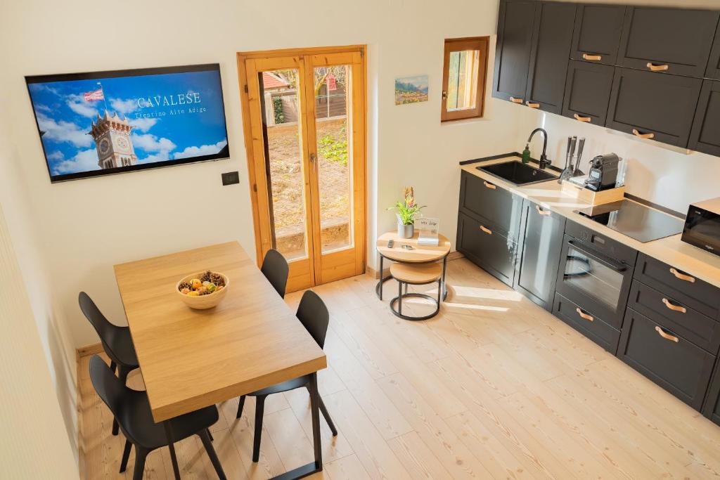 a kitchen and dining room with a table and chairs at MH Luxury Apartments in Cavalese