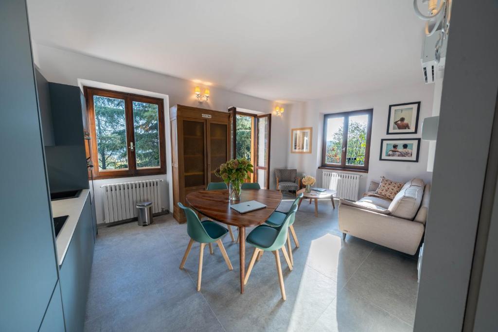 a living room with a table and chairs and a couch at Uliveto Moriondo in Salò