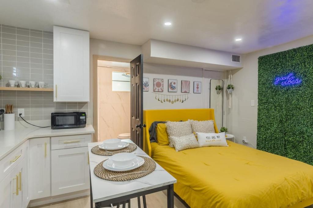a small kitchen with a yellow bed in a room at CUTE and COZY studio w jacuzzi in Orlando