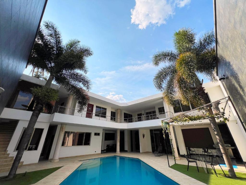 a house with a swimming pool and palm trees at Casa Vacacional Jpol in Cali