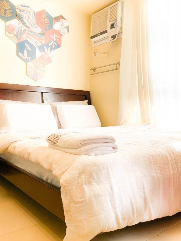 une chambre avec un lit avec une fenêtre dans l'établissement Trendy Studio at Avida Riala It Park, à Mabolo