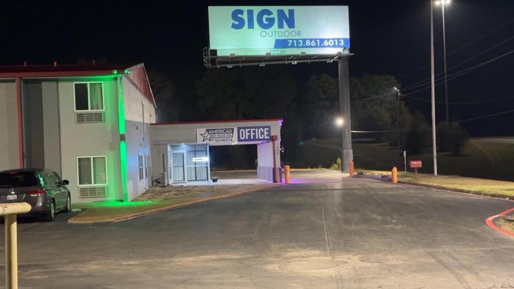 a sign in front of a gas station at night at Americas Best Value Inn Marshall in Bel Air