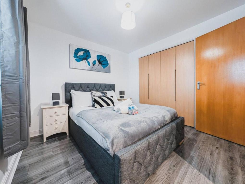 - une chambre avec un grand lit et une armoire en bois dans l'établissement Modern 2-Bed Near Braehead, à Renfrew