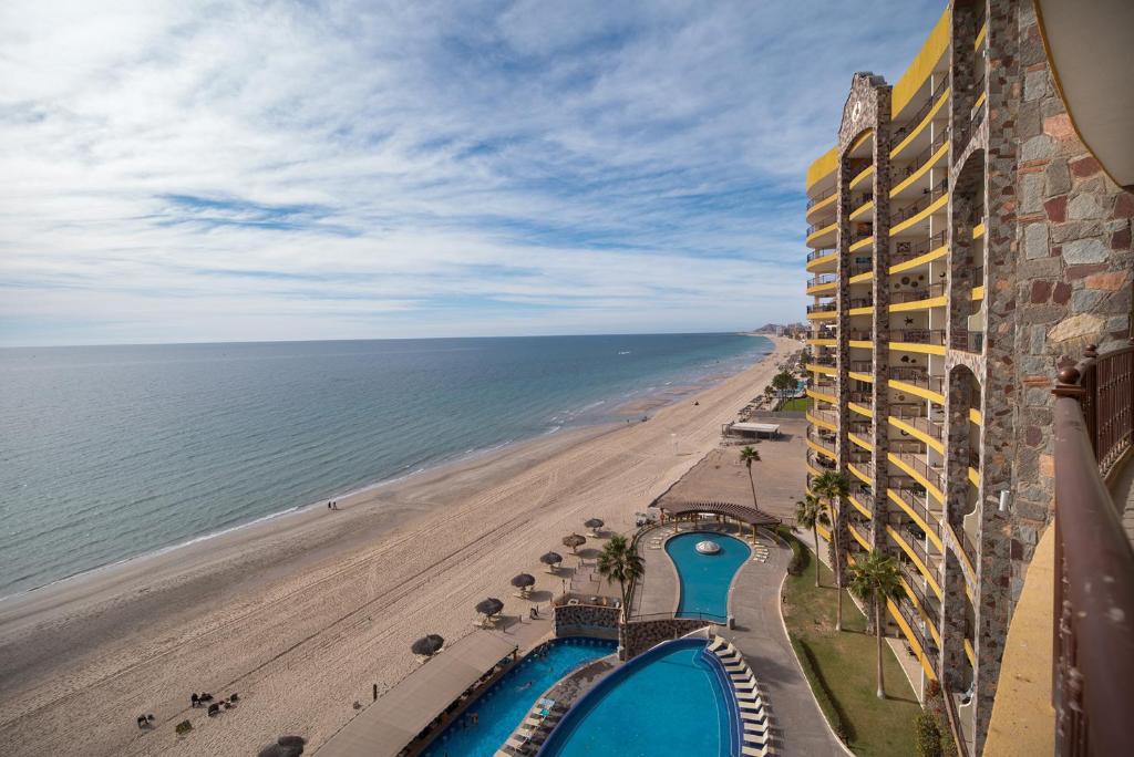 a view of the beach from the balcony of a resort at Viva Beach Life Comfortable Oceanfront in Puerto Peñasco