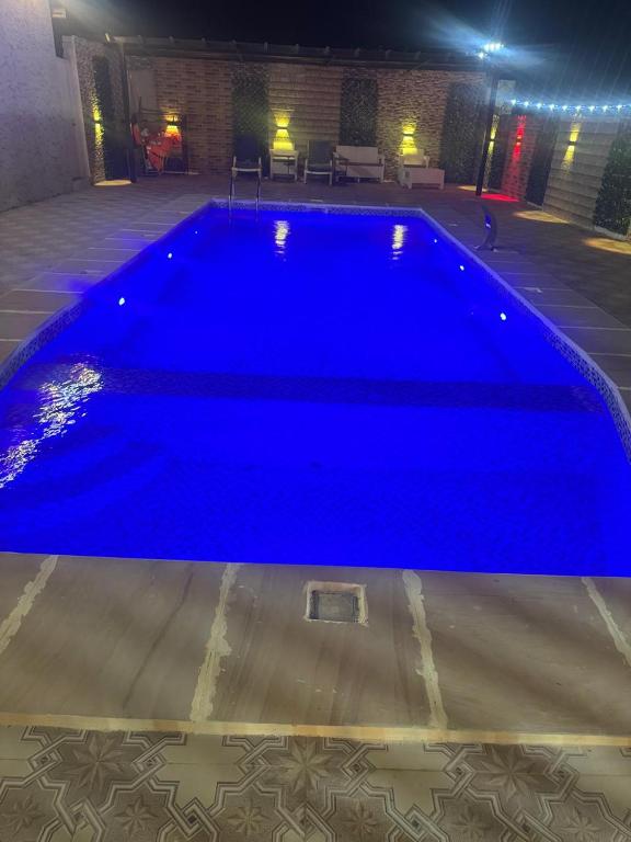 a large blue swimming pool in a building at Mountain Park Rest in Ḑab‘ah