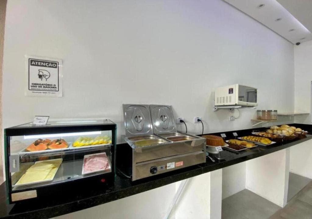 een bakkerijtoonbank met diverse soorten gebak bij Mar Suites Tenório in Ubatuba