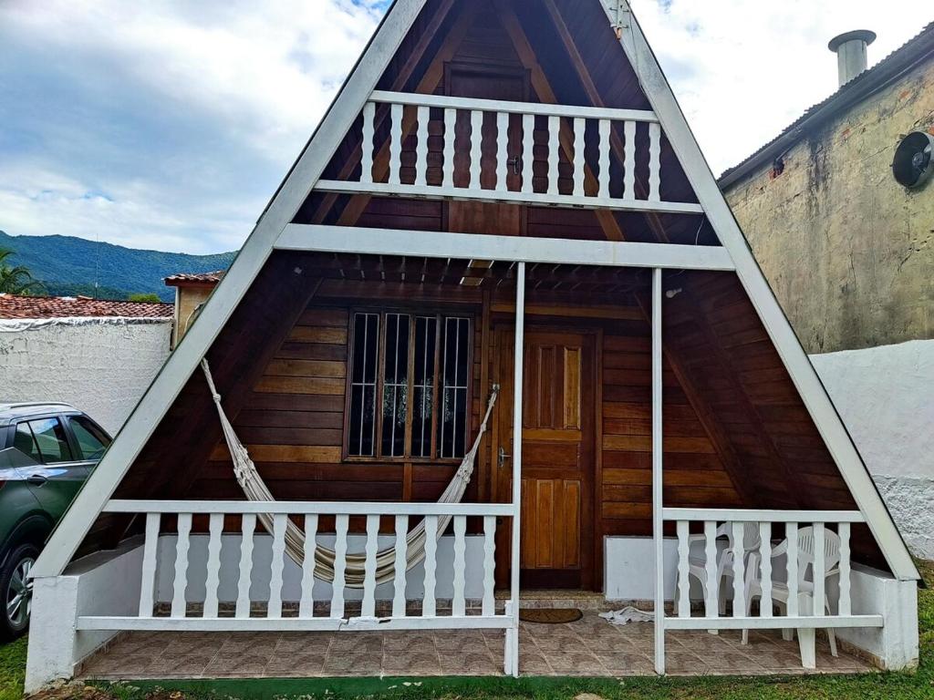 a small house with a triangular roof and a staircase at Chalé da Vandisa in Ilhabela