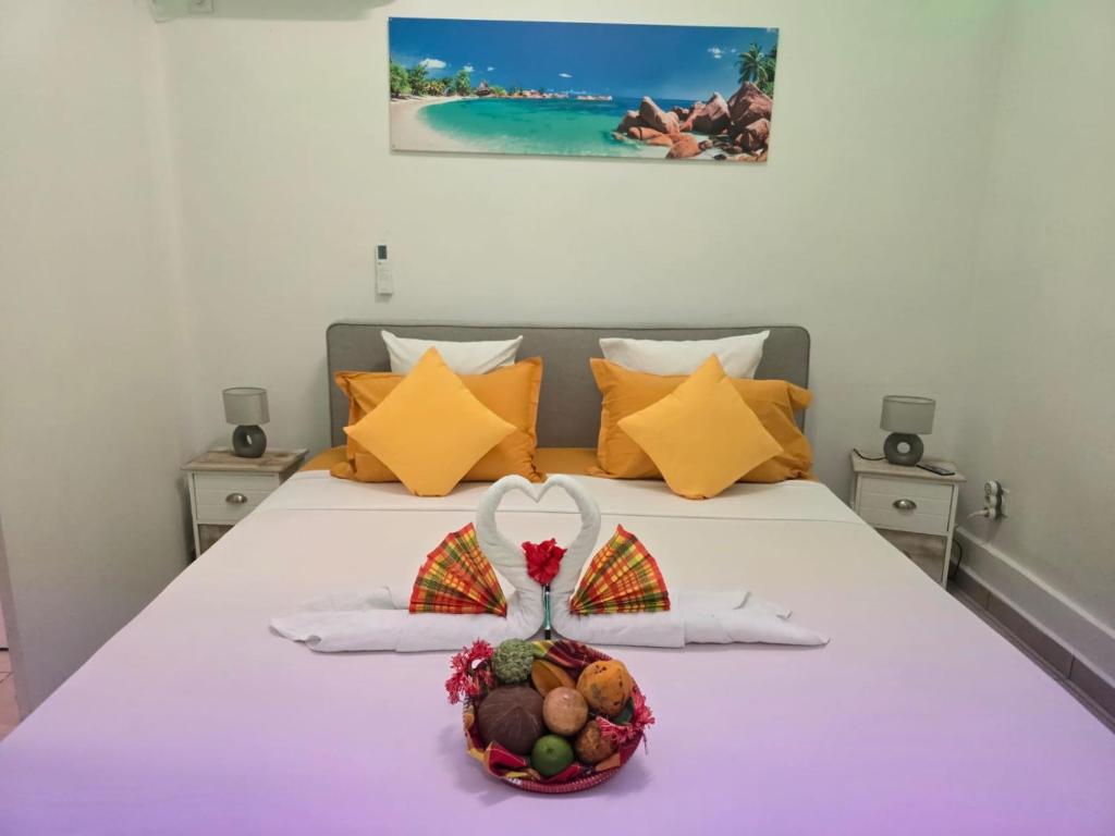ein Schlafzimmer mit einem Bett mit einem Obstkorb darauf in der Unterkunft Location bungalow in Le Gosier