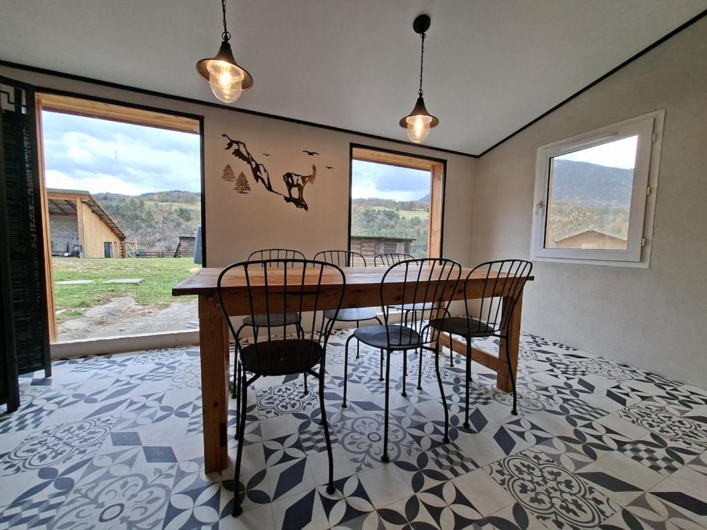 a dining room with a table and four chairs at Gîte de Fond Carle in Miribel-Lanchâtre