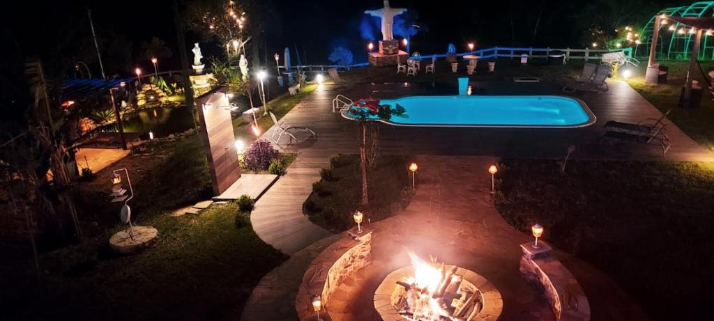 ein Schwimmbad in der Nacht mit Achterbahn in der Unterkunft Pousada Finca dos Anjos in Passa Quatro
