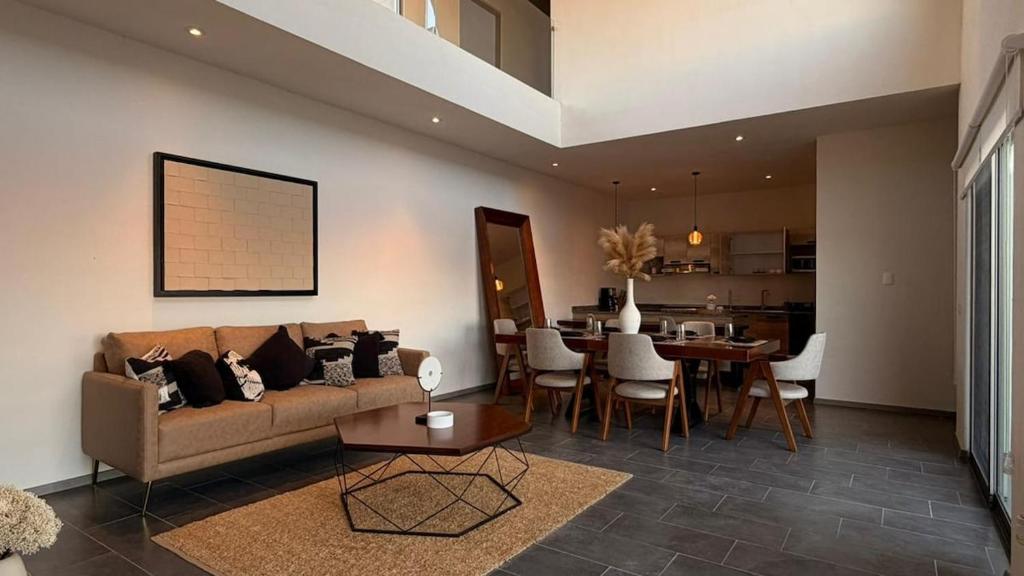 a living room with a couch and a dining room at Hermosa Casa en San Miguel con cancha de pádel in San Miguel de Allende