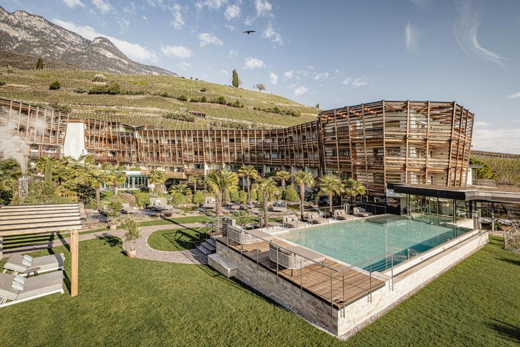 a resort with a swimming pool and a building at Lake Spa Hotel SEELEITEN in Caldaro