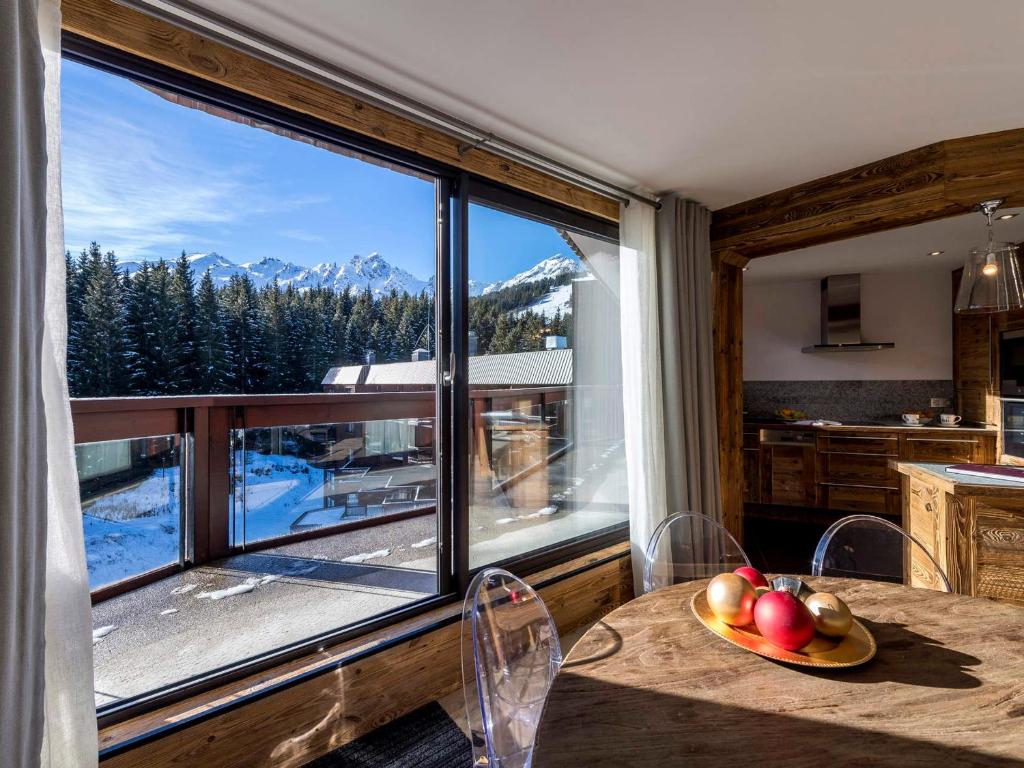 a kitchen with a table and a large window at Appartement de standing à Courchevel avec vue, proche des pistes, parking inclus - FR-1-575-59 in Courchevel
