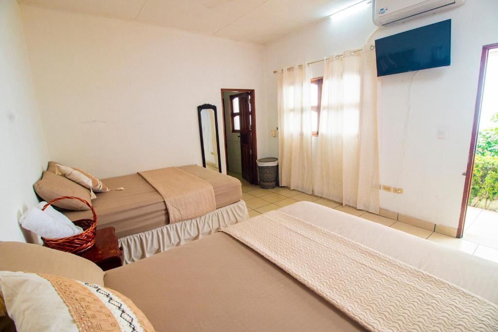 Una habitación de hotel con dos camas y una ventana. en Casa Imabite, en León