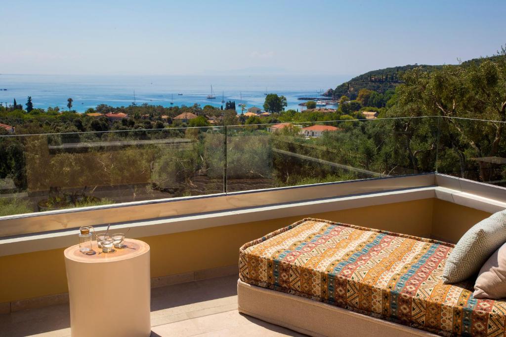 a room with a bed and a large window at Golden Bay Suites & Maisonettes in Parga