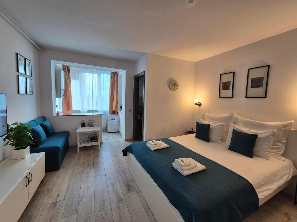 a bedroom with a large bed and a blue couch at ZARA STUDIO BRASOV in Braşov