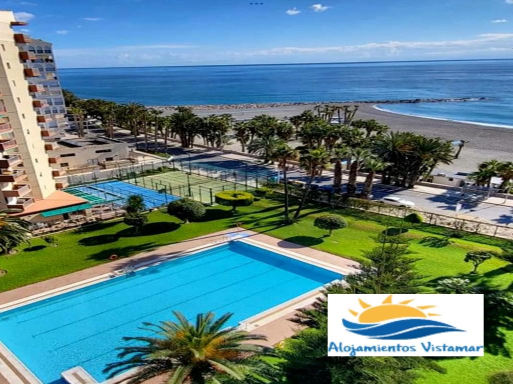 eine Luftaufnahme eines Resorts mit Swimmingpool und Strand in der Unterkunft Apartamento Las Góndolas Playa ALOJAMIENTOS VISTAMAR in Almuñécar