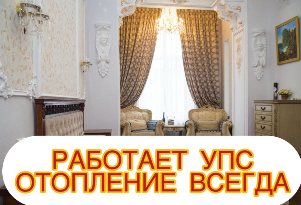 a living room with a window with curtains and chairs at Barocco on Nekrasov in Odesa