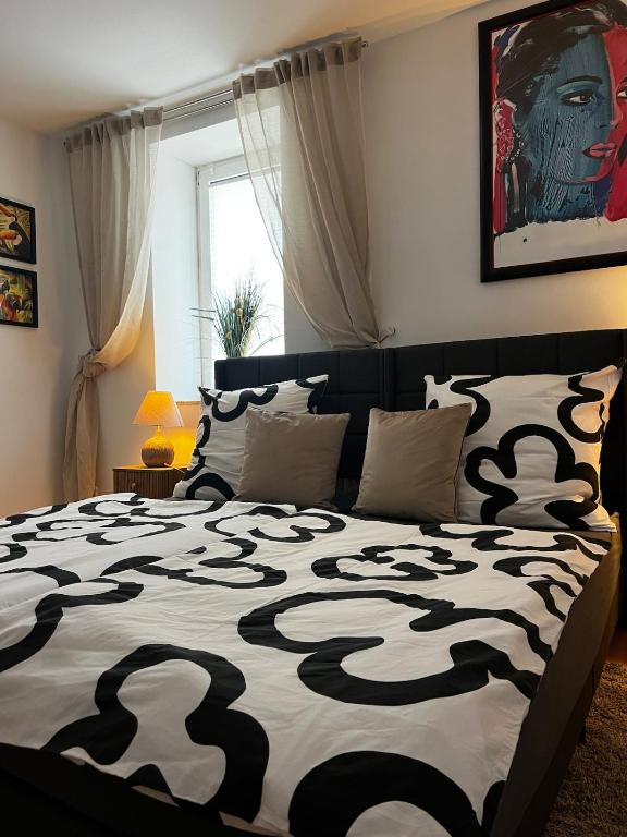 a bedroom with a bed with a black and white comforter at Apartment im Grünen -Garden in Chemnitz