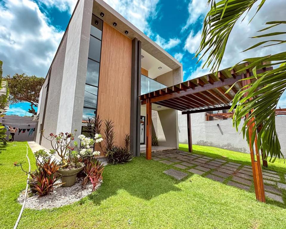 ein Haus mit einem großen Fenster und einem Rasenplatz in der Unterkunft Casa Moderna & Conforto in Eusébio