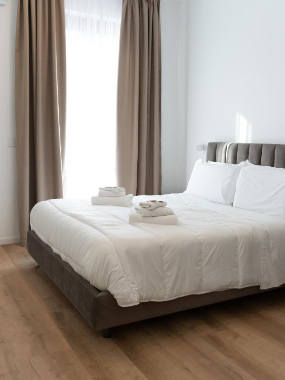 a bedroom with a bed with white sheets and a window at VILLA ISABELLA Ospedale Cisanello in Pisa