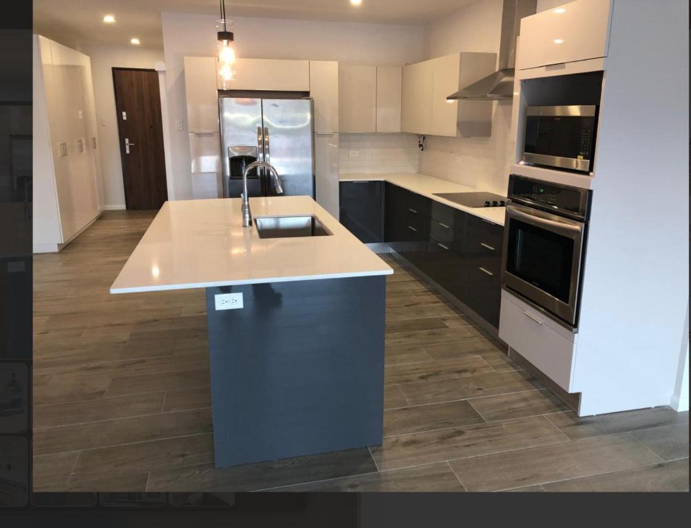 Una cocina grande con fregadero y estufa. en The Executive Suite, en Puerto España