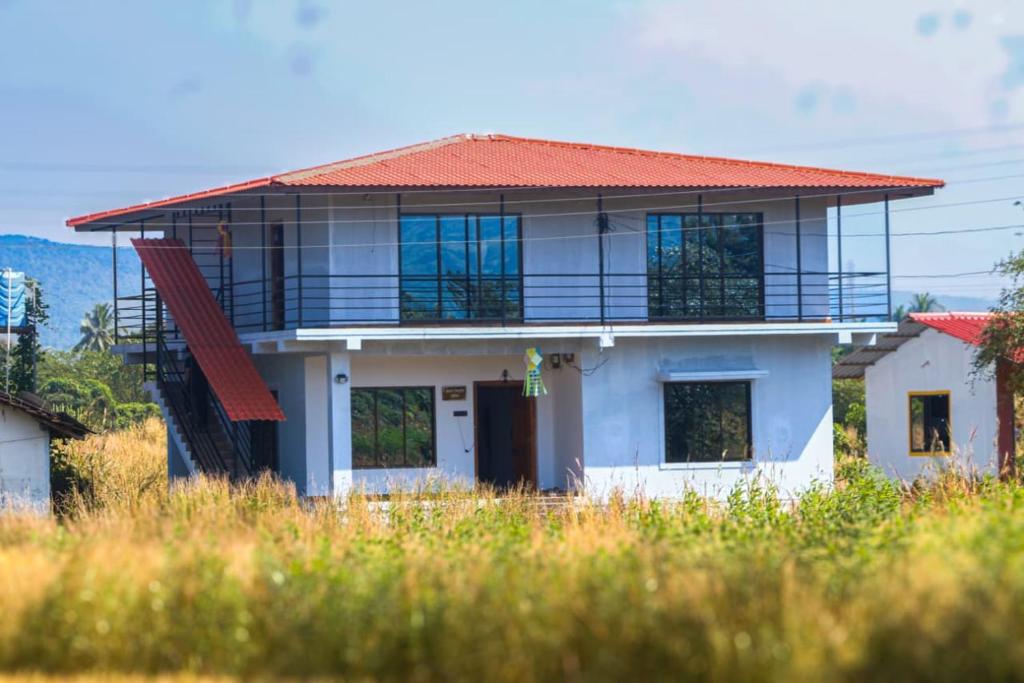ein weißes Haus mit einem Balkon darauf in der Unterkunft Anugraha Homestay in Alībāg