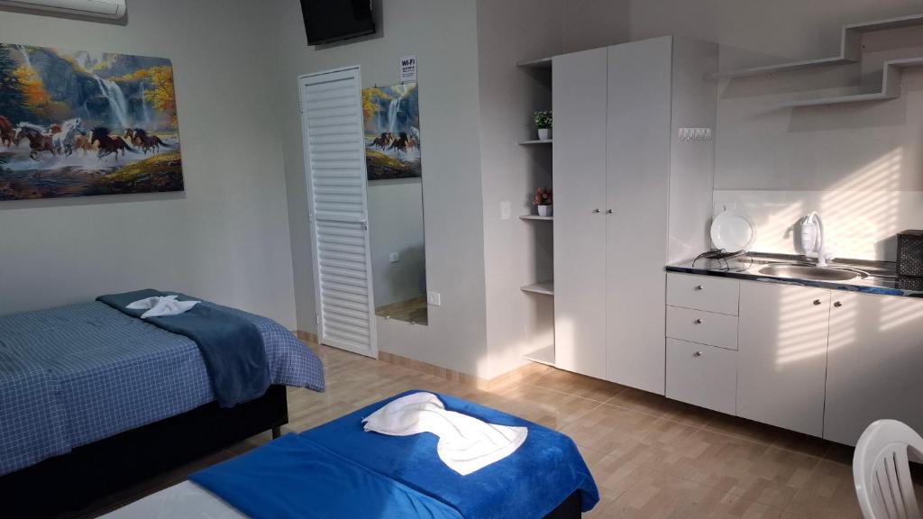 a bedroom with a bed and a sink in it at Suíte Harmonia 1 in Campo Grande