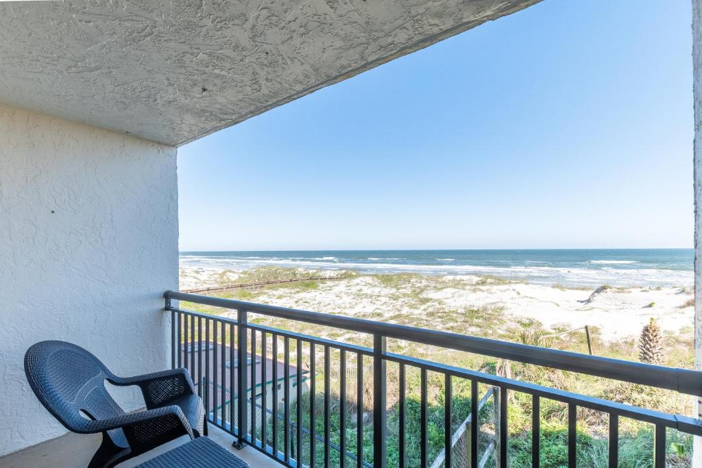 ein Balkon mit zwei Stühlen und Blick auf das Meer in der Unterkunft Long Time No Sea! Direct OCEANFRONT Condo - End Unit Double Ocean View - Crescent Beach, Saint Augustine Florida in Crescent Beach
