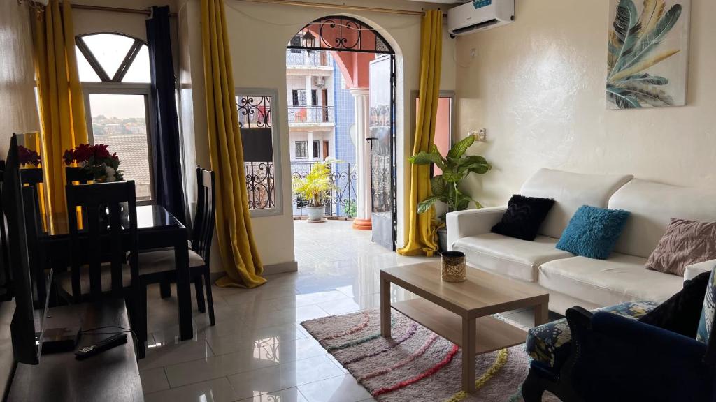 a living room with a white couch and a table at BARAN Home in Yaoundé