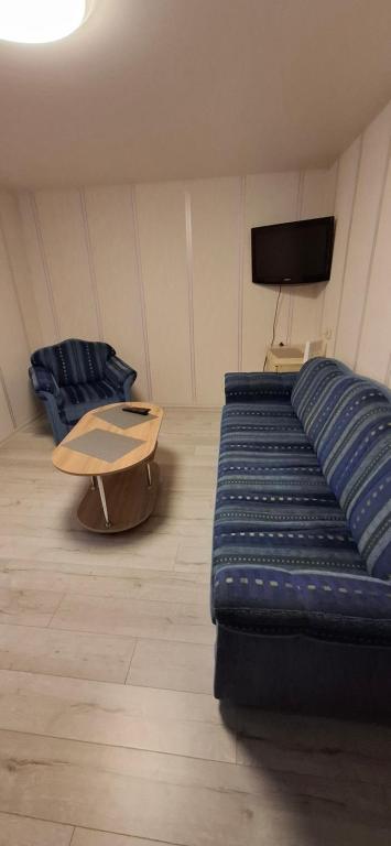 a living room with a blue couch and a table at Pas Dianą 1 aukštas in Jurbarkas