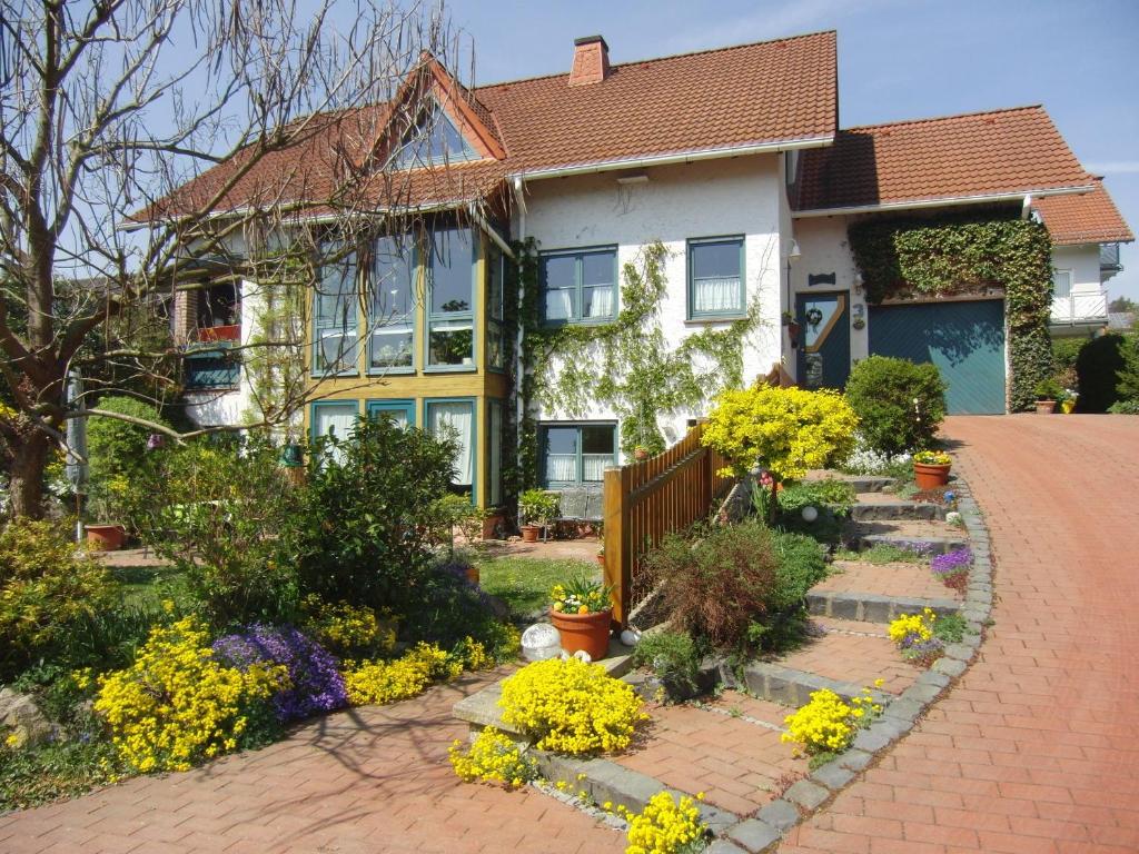 una casa con una entrada de ladrillo y flores delante de ella en Ferienwohnung Rösner, en Herzhausen